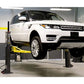 White SUV lifted by MaxJax M7K portable 2 post car lift, showcasing advanced safety and engineering.