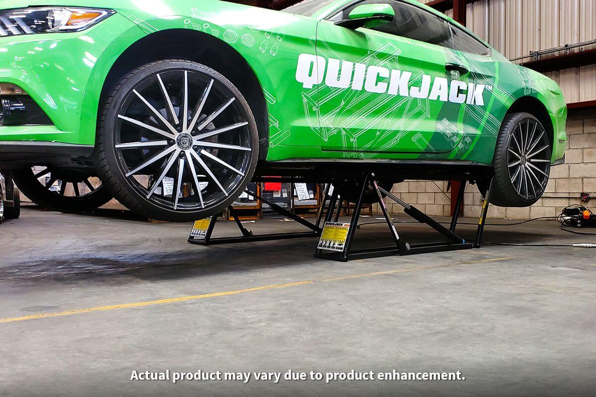 QuickJack 7000TL portable car lift raising a green Mustang in an auto shop, showcasing its 7000 lb capacity.