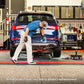 Mechanic using QuickJack 7000TL portable car lift in a garage, showcasing 7000 lb capacity for trucks and SUVs.