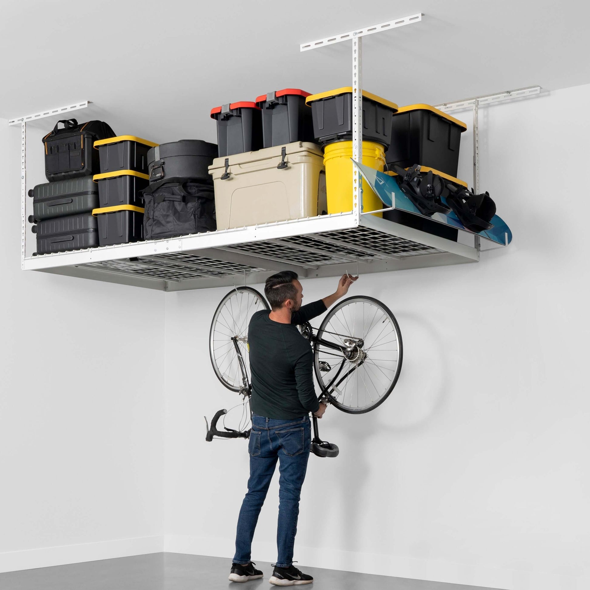 Man organizing items on a SafeRacks 4' x 8' overhead garage storage rack.