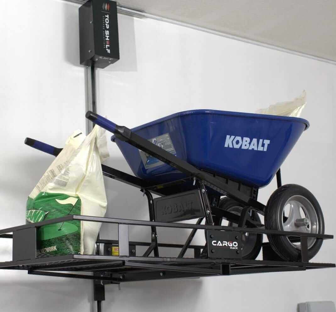 Kobalt wheelbarrow and bags stored on a motorized overhead lift by Top Shelf Storage Solutions.