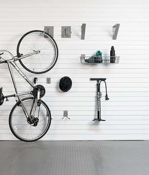 Wall-mounted bike storage system featuring a bike, hooks, basket, and pump for efficient organization.