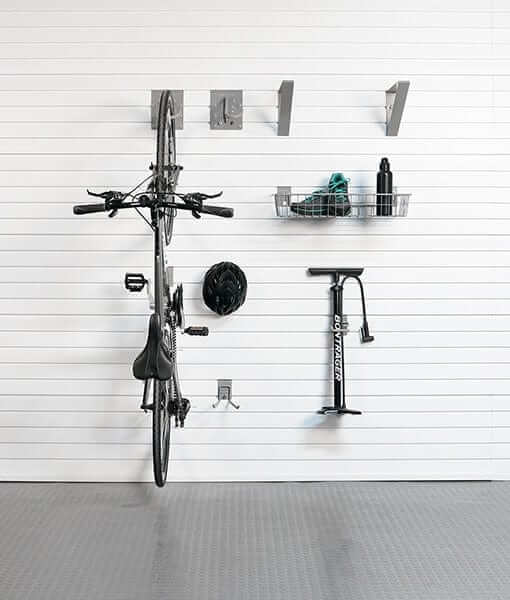 Bike stored on wall with storage hooks and accessories in a clean garage setting, showcasing the storeWALL Basic Bike Bundle.